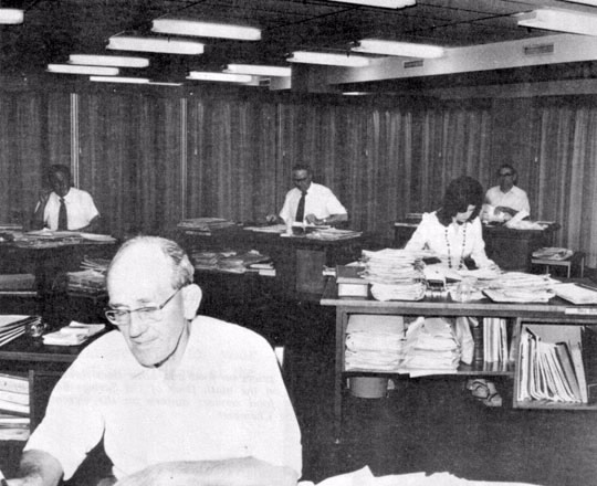 Company assessing in Sydney in 1975, the rows of desks have gone.The assessors are Reg Bernsten, Len Kennison, Bev Butler, George Watts, Nick McIntyre.